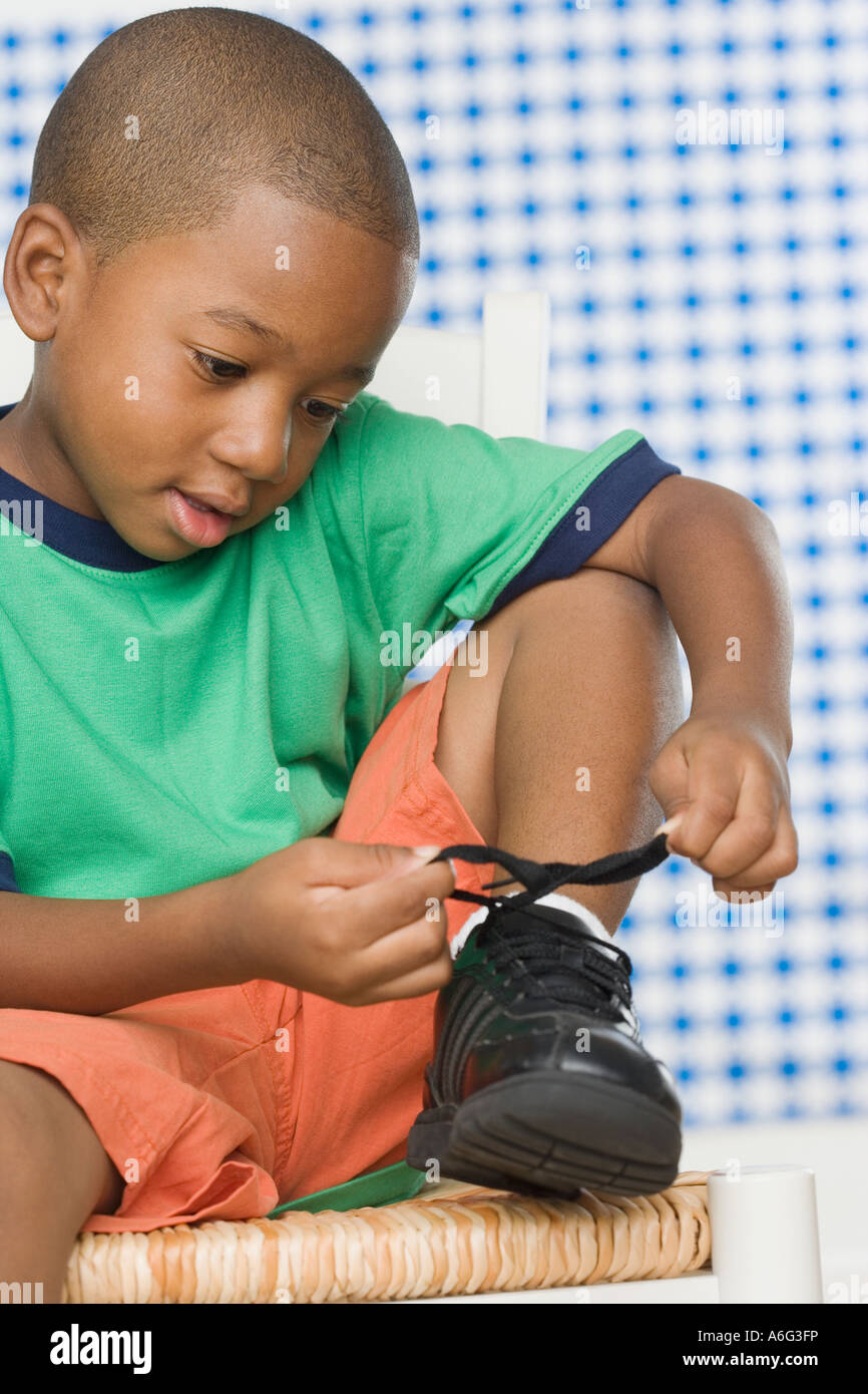 Young African boy tying shoe Stock Photo Alamy