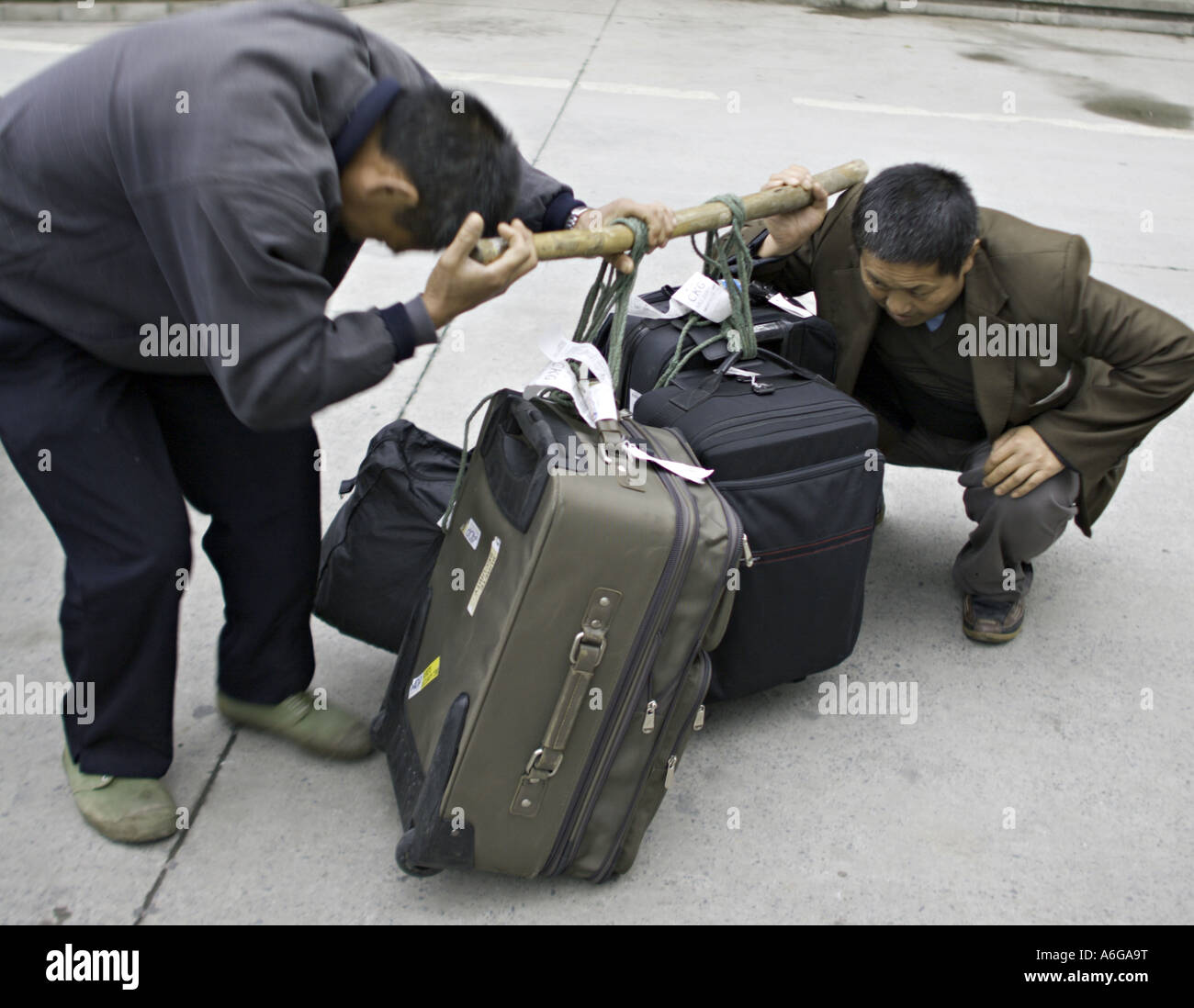 CHINA CHONGQUING Chinese luggage handlers strain to lift several heavy