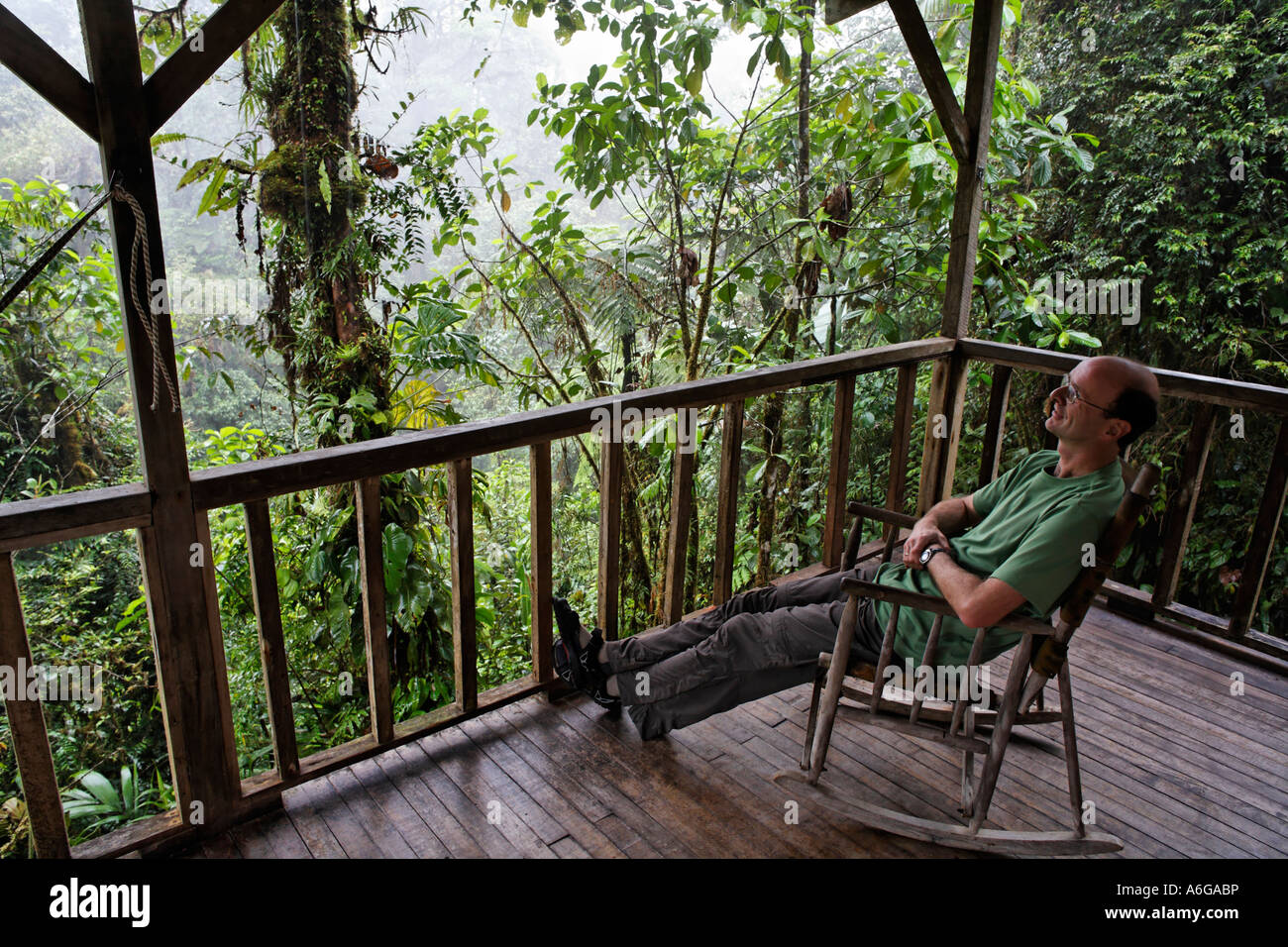 Man in rocking chair, Rara Avis Lodge, River Edge Cabin, Las Horquetas, Costa Rica Stock Photo