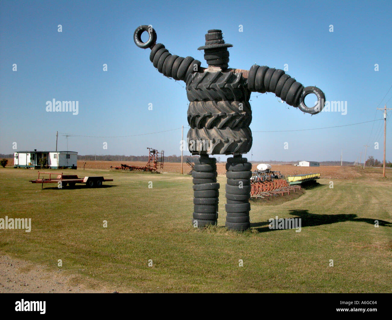 Man made from old truck and car and farm tires at business frontage on