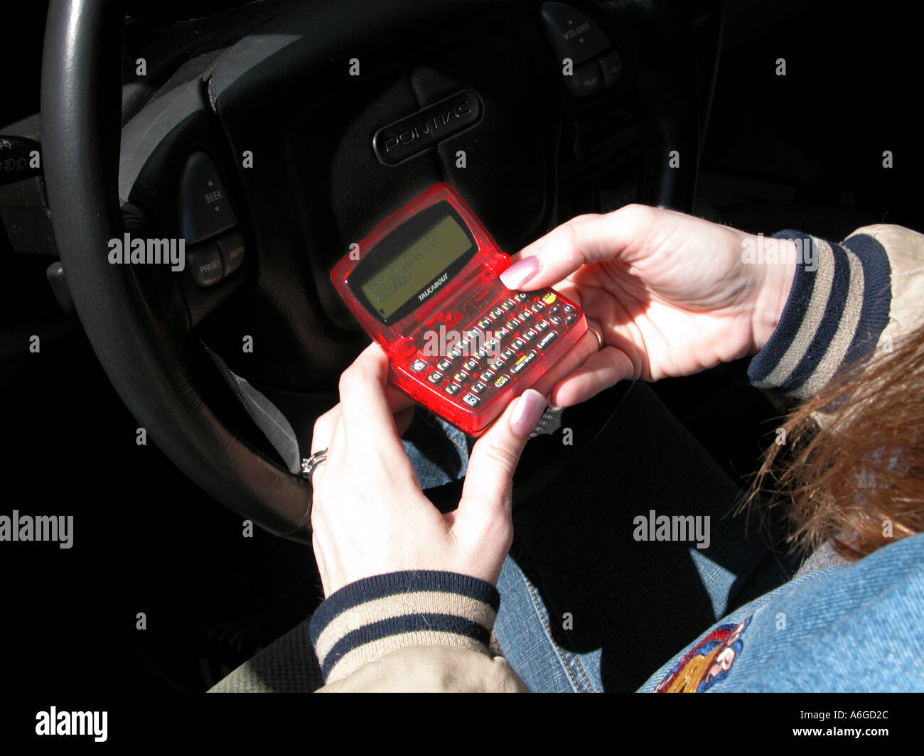 Woman reading old and out of date hand help pager beeper with key board and screen Stock Photo