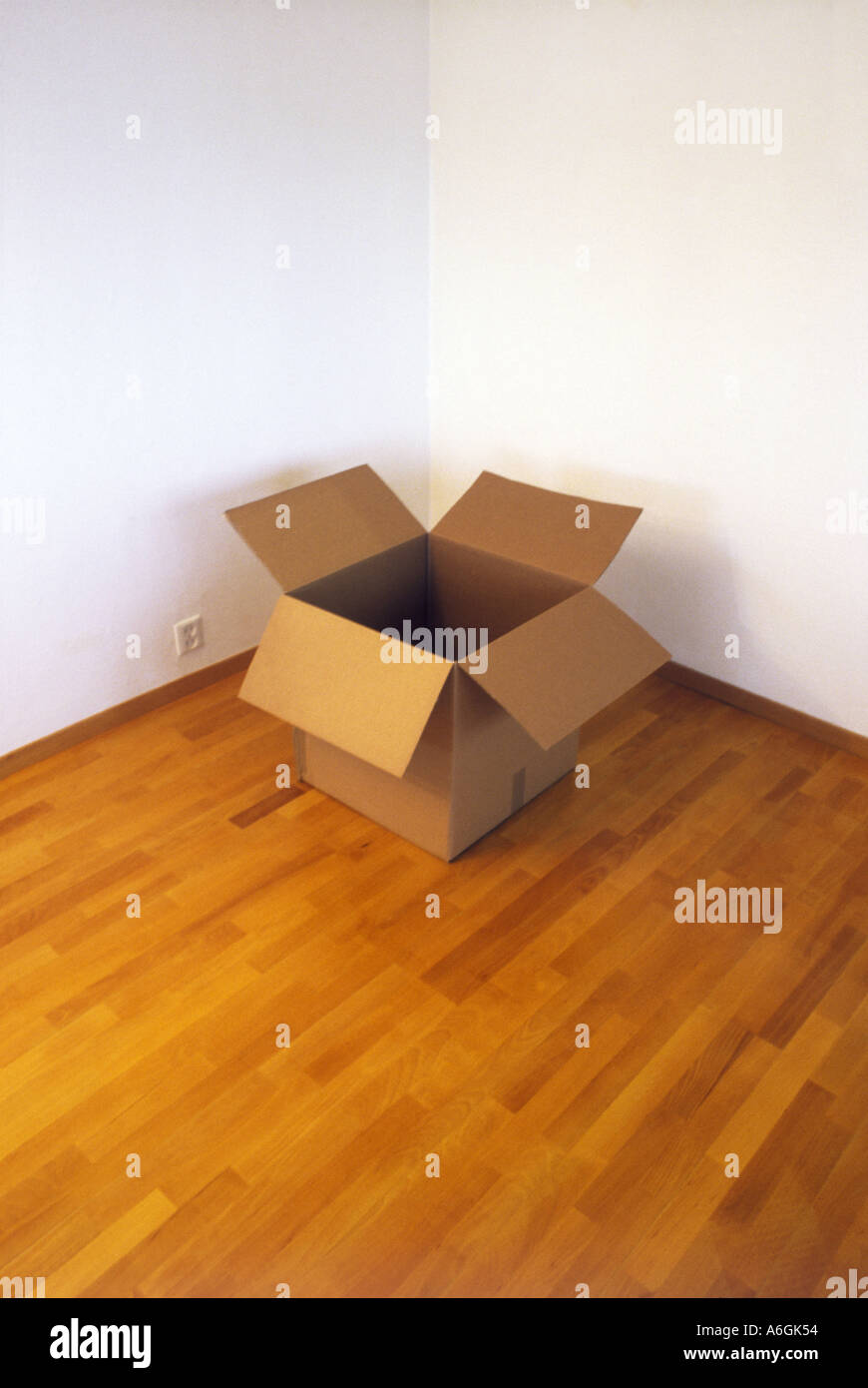 Empty Cardboard Box in the Corner of a Room Stock Photo