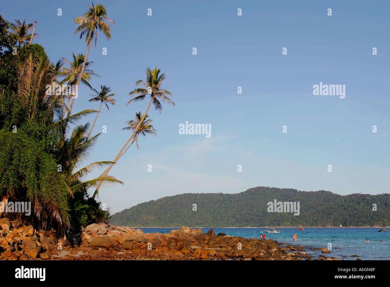 Visitors snorkel off rocks at low tide Perhentian Kecil Malaysia Stock Photo