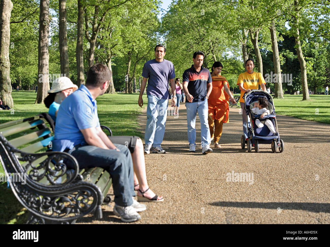 a group of young multi-racial people walk through a Park in London ...