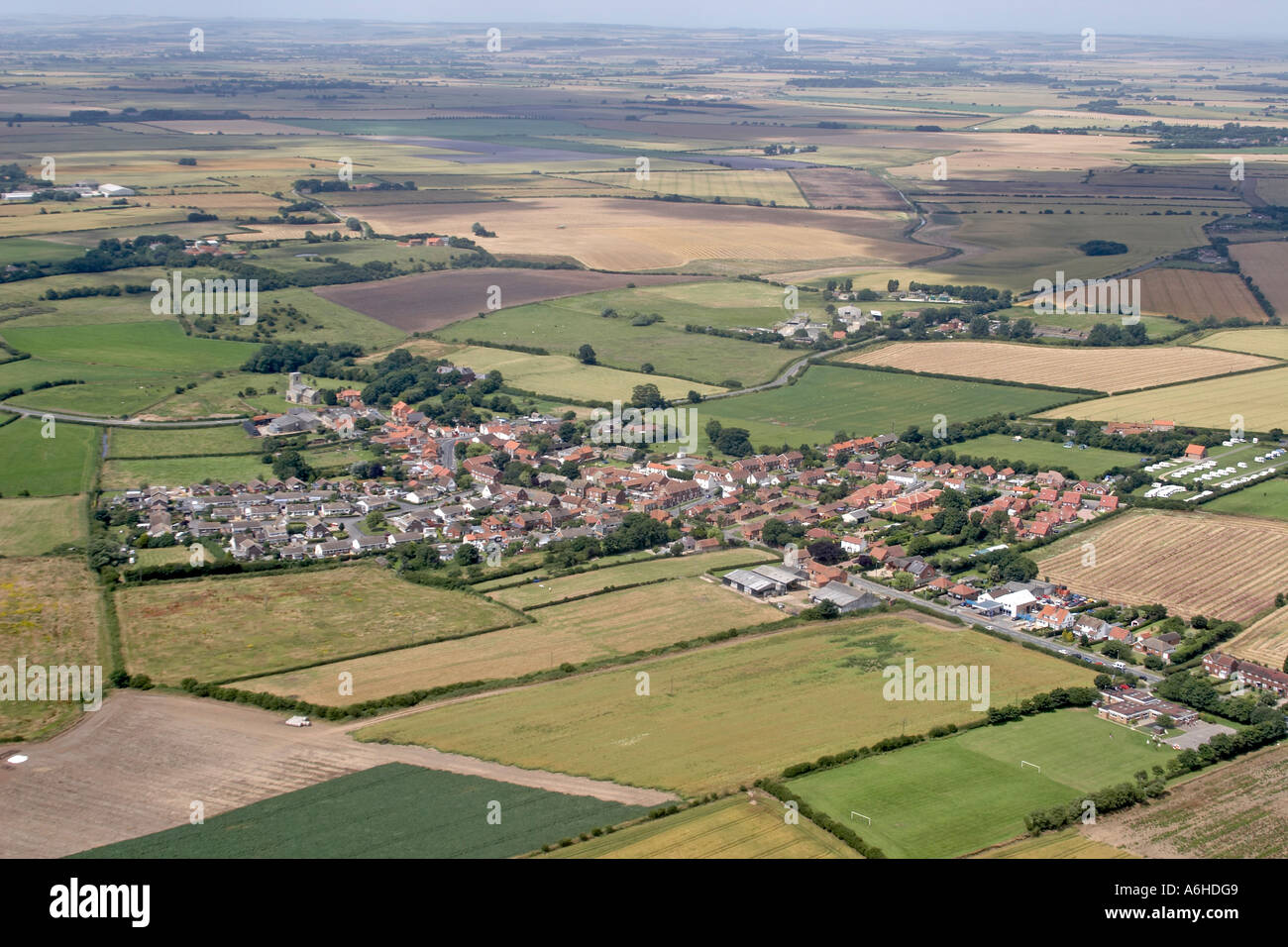 High level oblique aerial view of Skipsea village with castle mound in ...