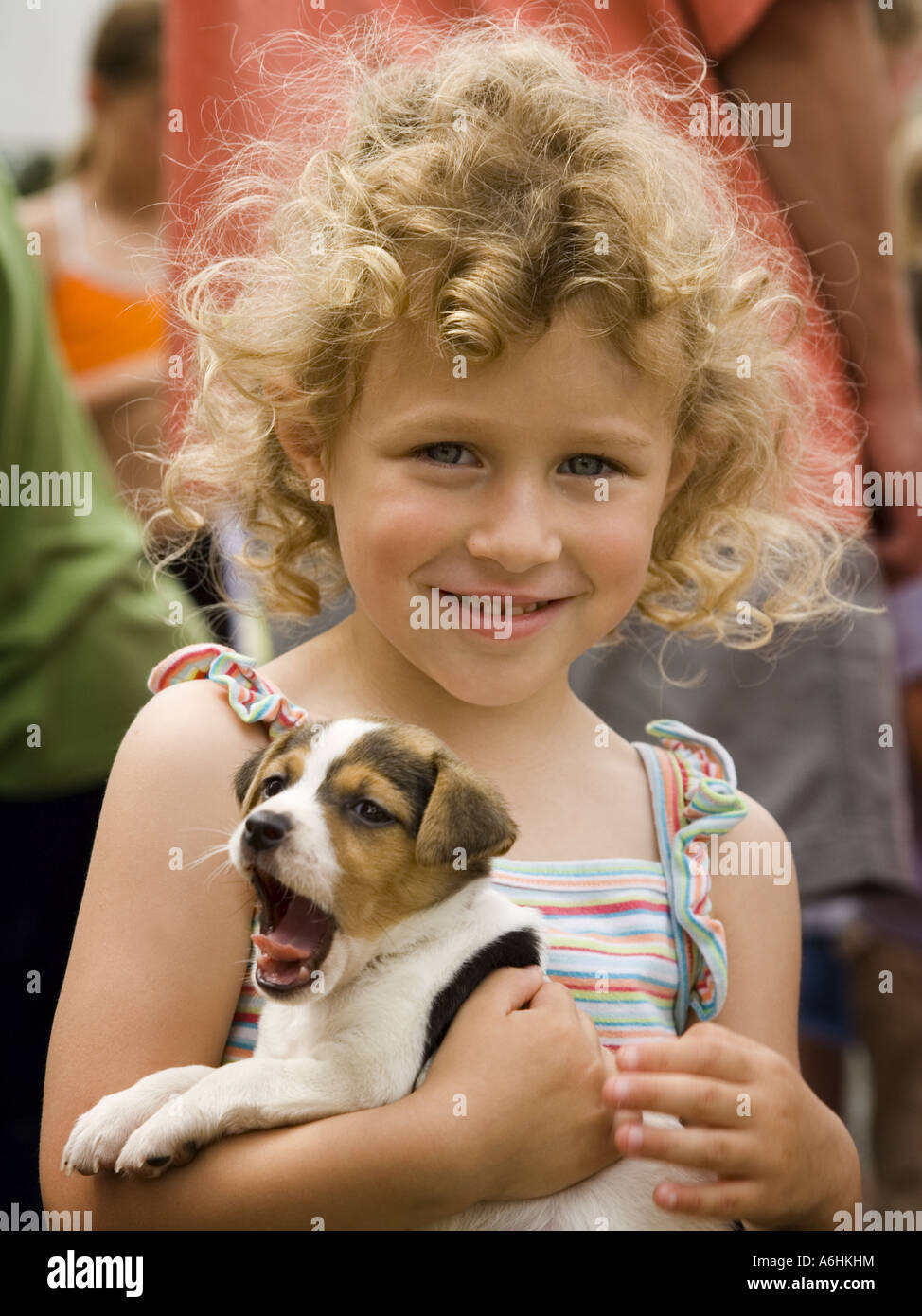 Child holding puppy yawn Stock Photo