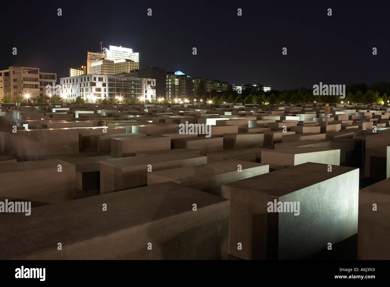 The lit Holocaust memorial at night with view of the multistoried buildings at the Potsdamer place, Berlin, Germany Stock Photo
