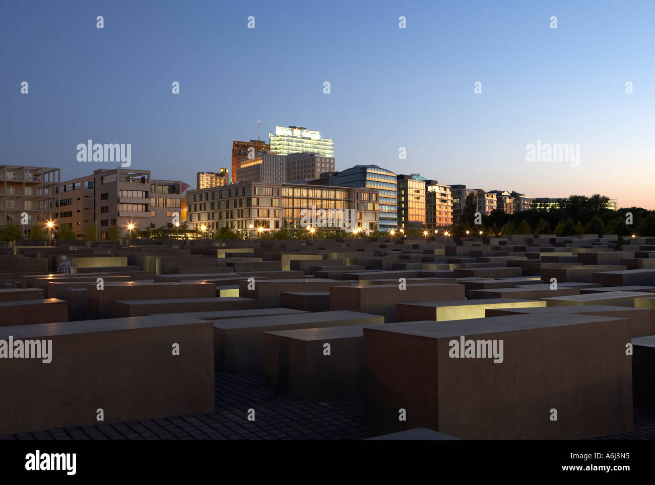 The lit Holocaust memorial at night with view of the multistoried buildings at the Potsdamer place, Berlin, Germany Stock Photo