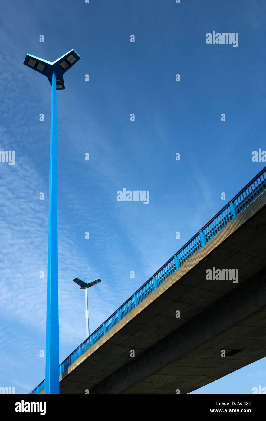 View from downside of two concrete road bridges with a high road lamp