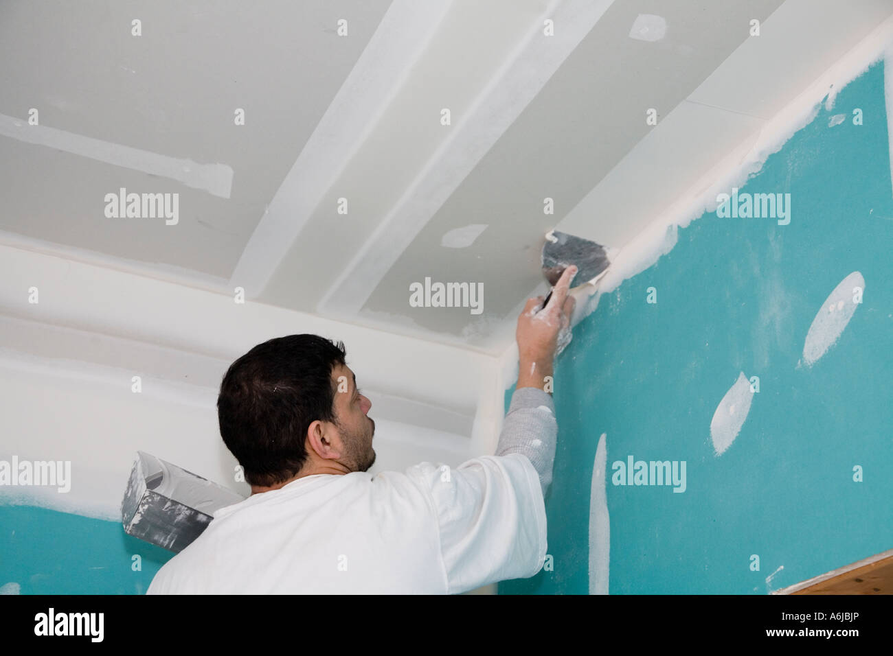 Immigrant Worker Applying Drywall Joint Compound Building 1