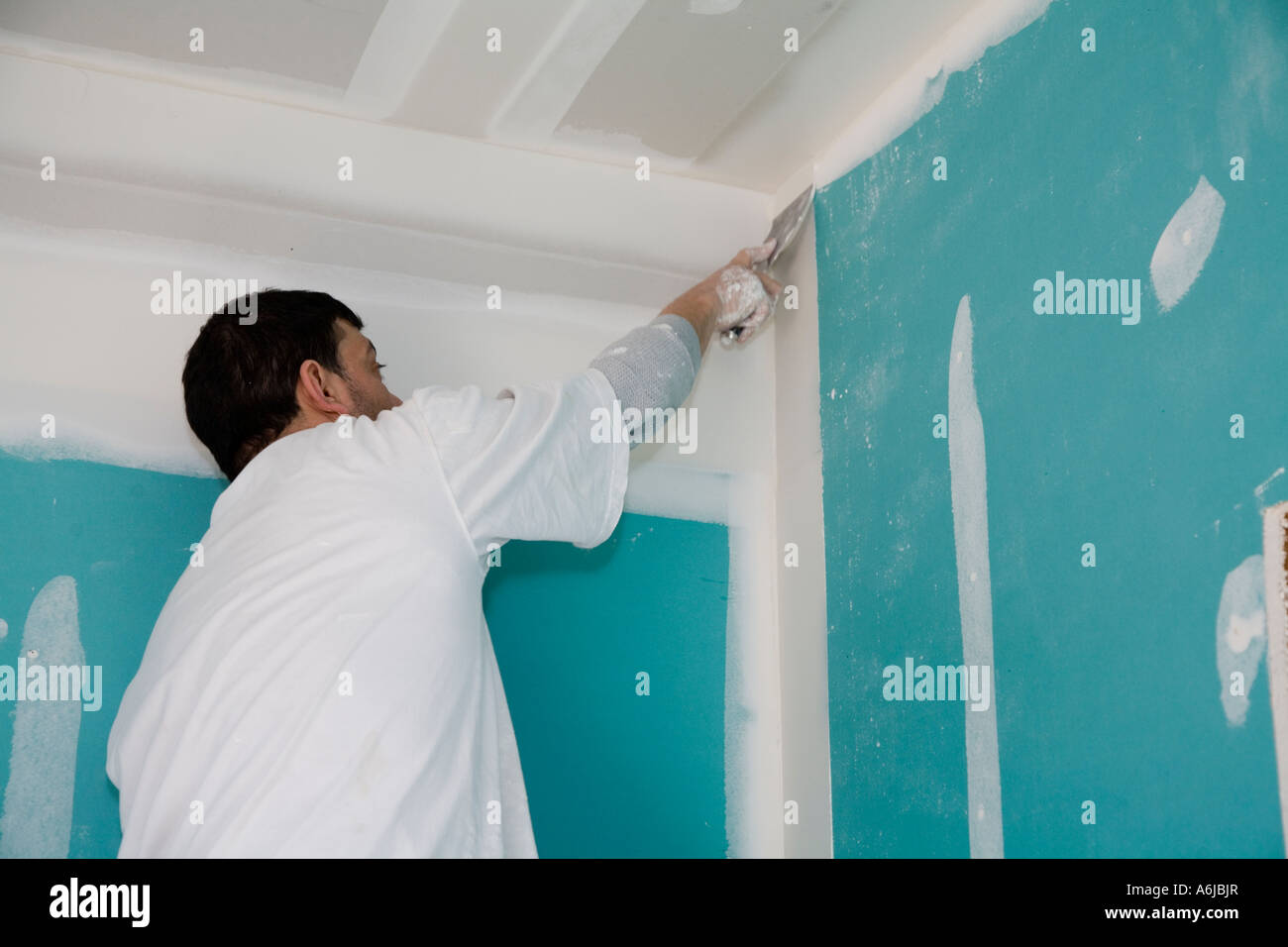 Immigrant Worker Applying Drywall Joint Compound Building 1