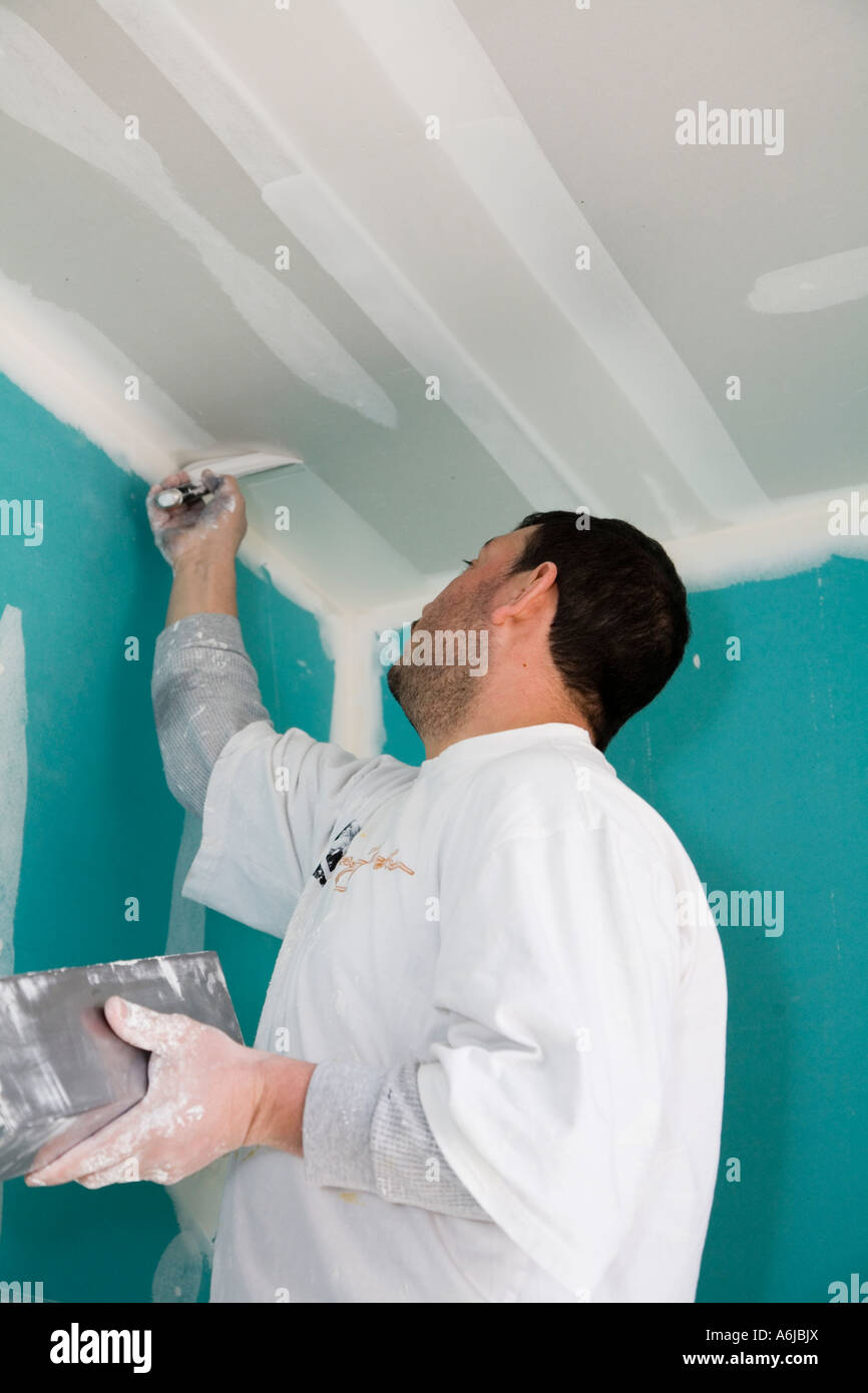 Immigrant Worker Applying Drywall Joint Compound Building 1