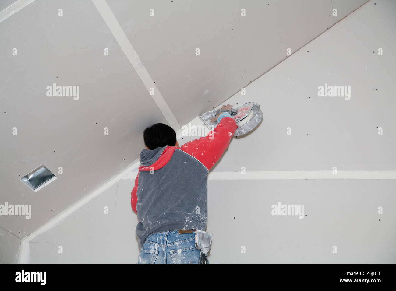 Immigrant Worker Applying Drywall Joint Compound Building 1