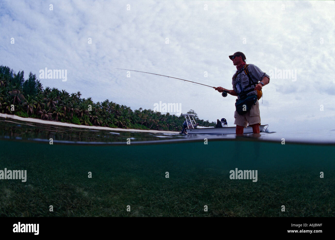 flyfisherman with bonefish in tropical lagoon Stock Photo