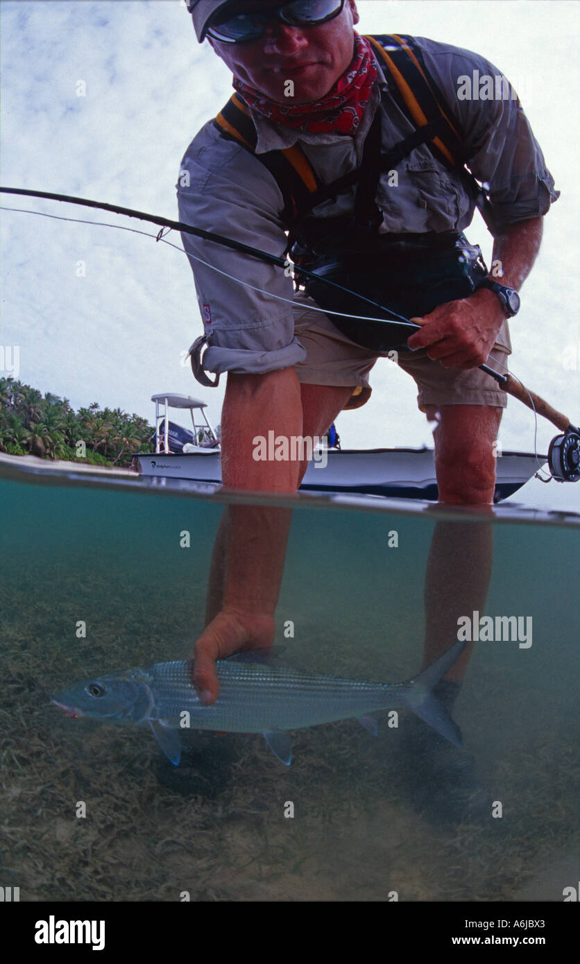 flyfisherman with bonefish in tropical lagoon Stock Photo