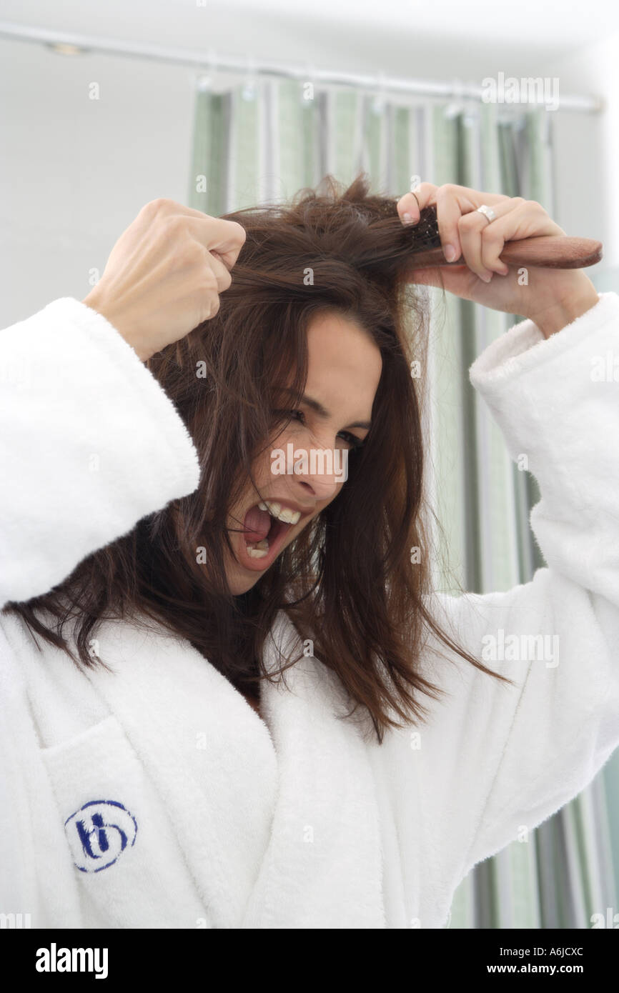 young woman brushing her tousled hair Stock Photo