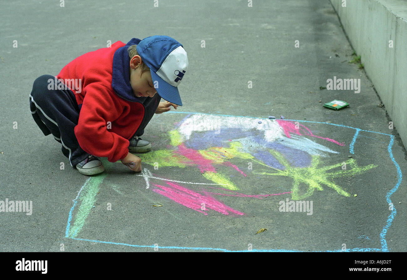 A boy drawing with chalk on the street, Poznan, Poland Stock Photo - Alamy