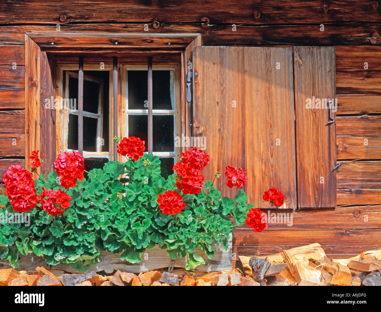 Window of a wooden alpine hut decorated with Geraniums, Austria Stock Photo
