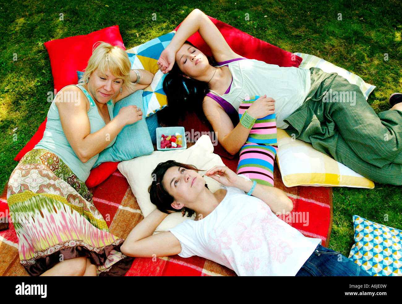 Young women lying on pillows in a garden Stock Photo
