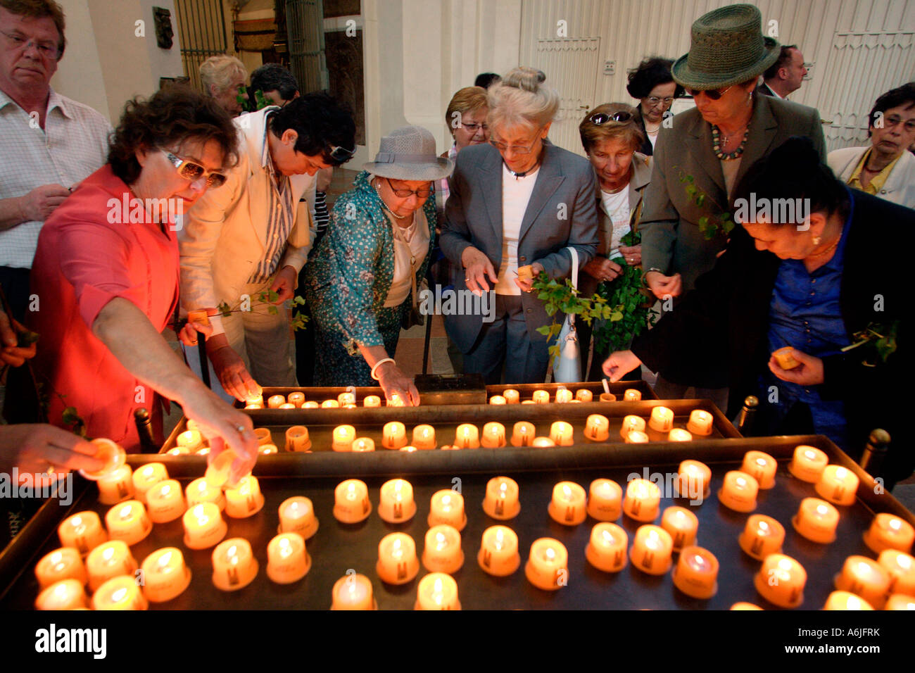 Women lighting candles in the Church of Our Lady in Munich, Germany Stock Photo