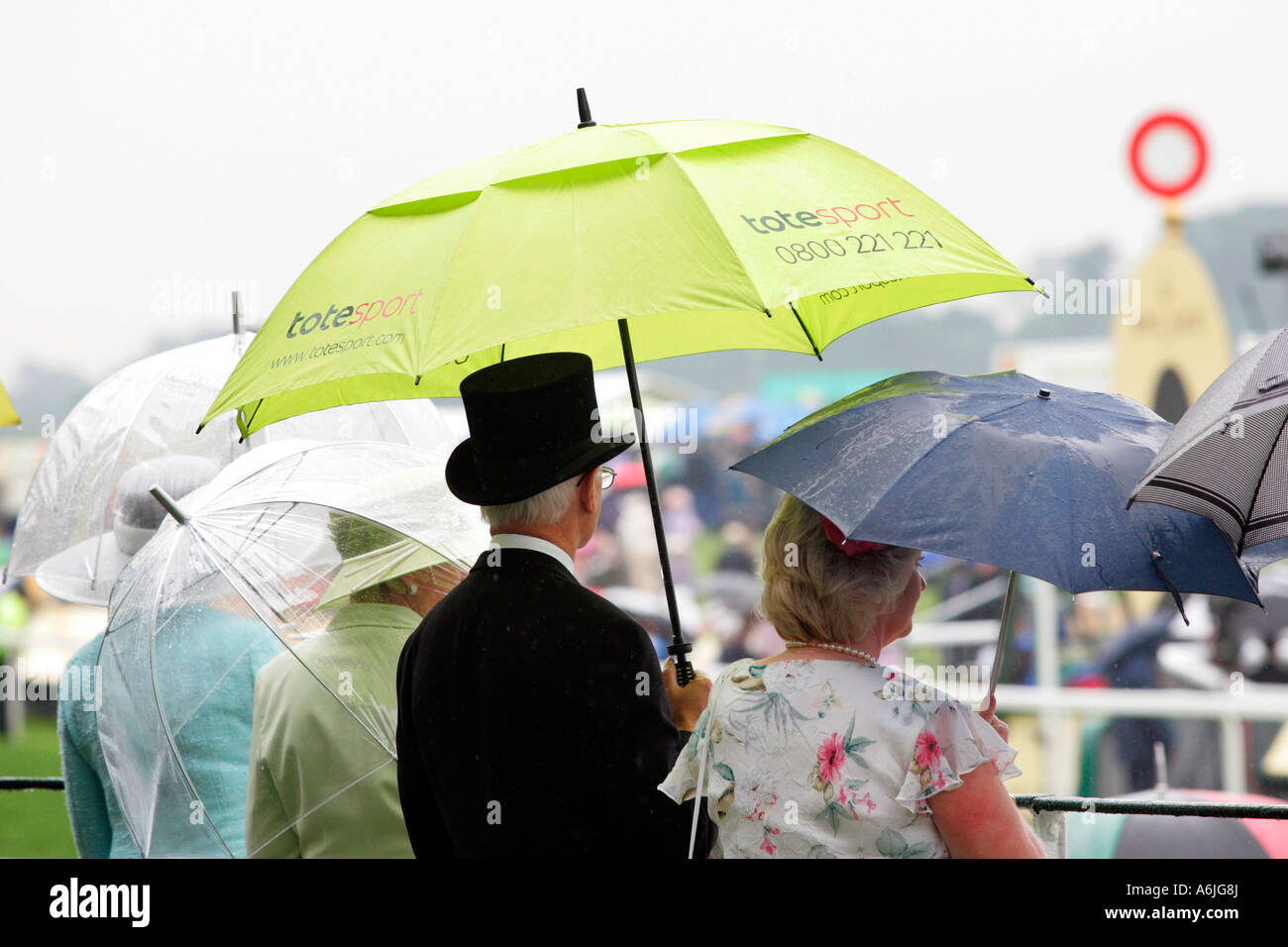 People with umbrellas at Royal Ascot horse race, York, Great Britain Stock Photo