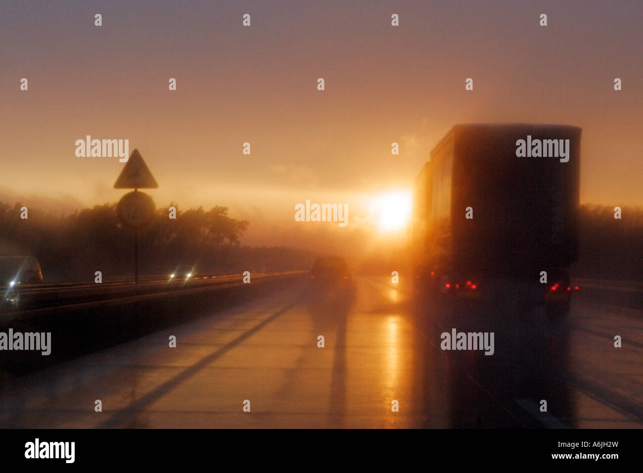 Cars on a highway at sunset, just after rainfall Stock Photo