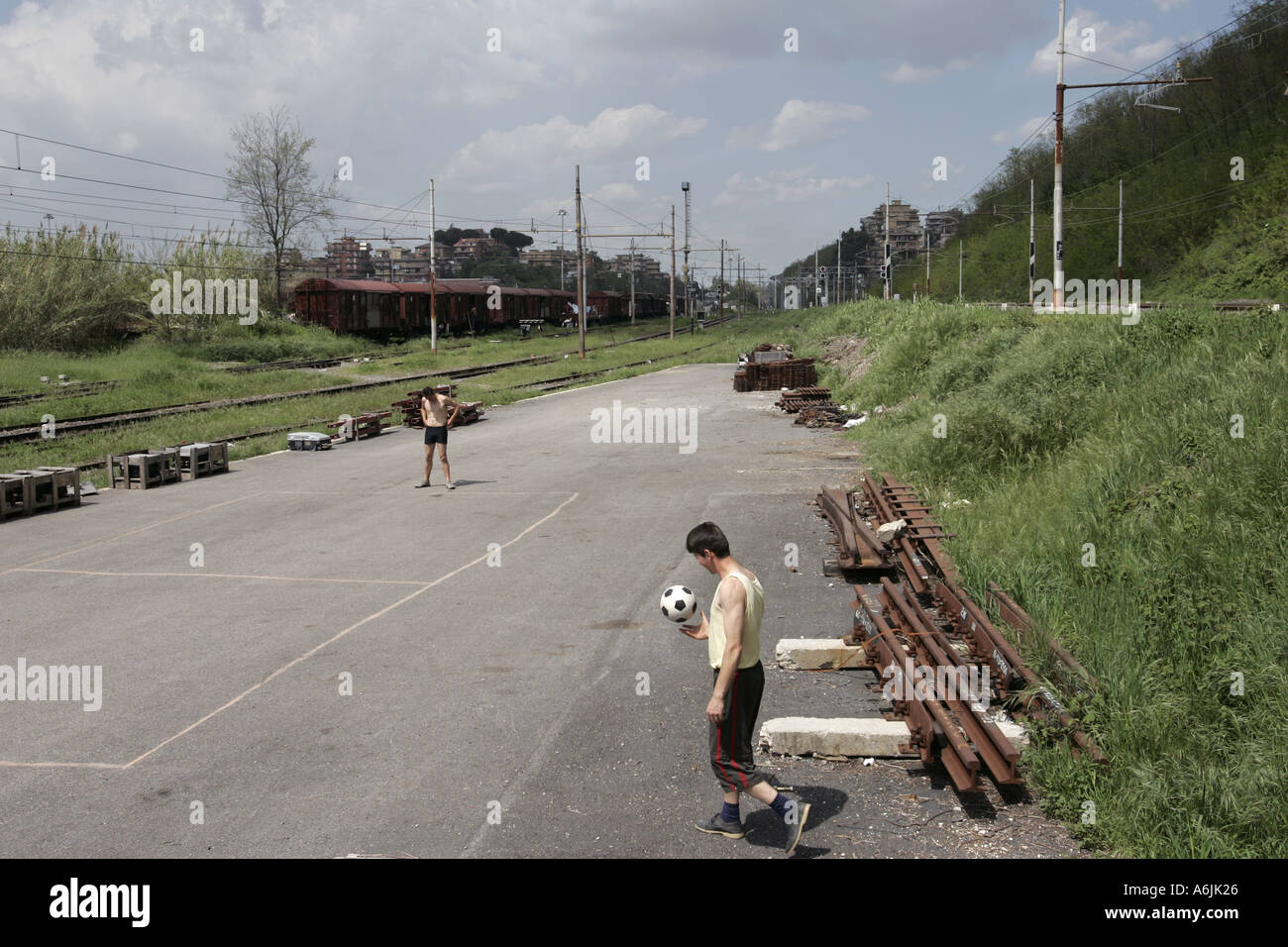 Two men playing football in a disused train station Rome italy Stock Photo