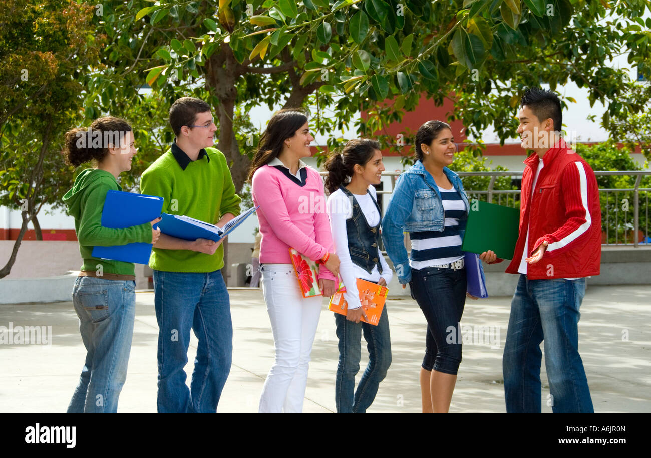 Group of senior ethnic multicultural teenage students talking having fun and relaxing in school playground campus Stock Photo