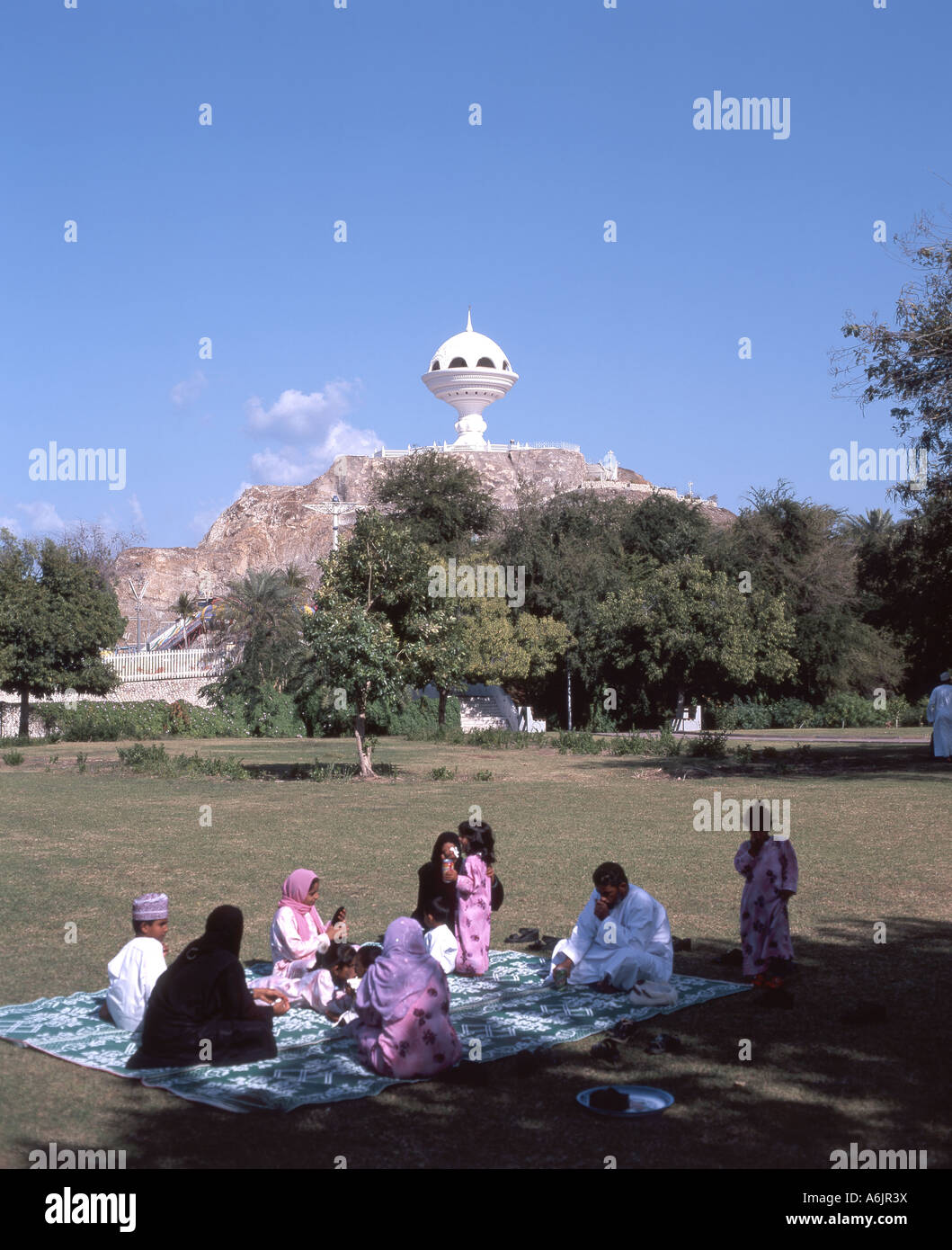 Family picnic in park and 'Incense Burner' Monument, Riyam City, Muscat, Masqat Governorate, Sultanate of Oman Stock Photo