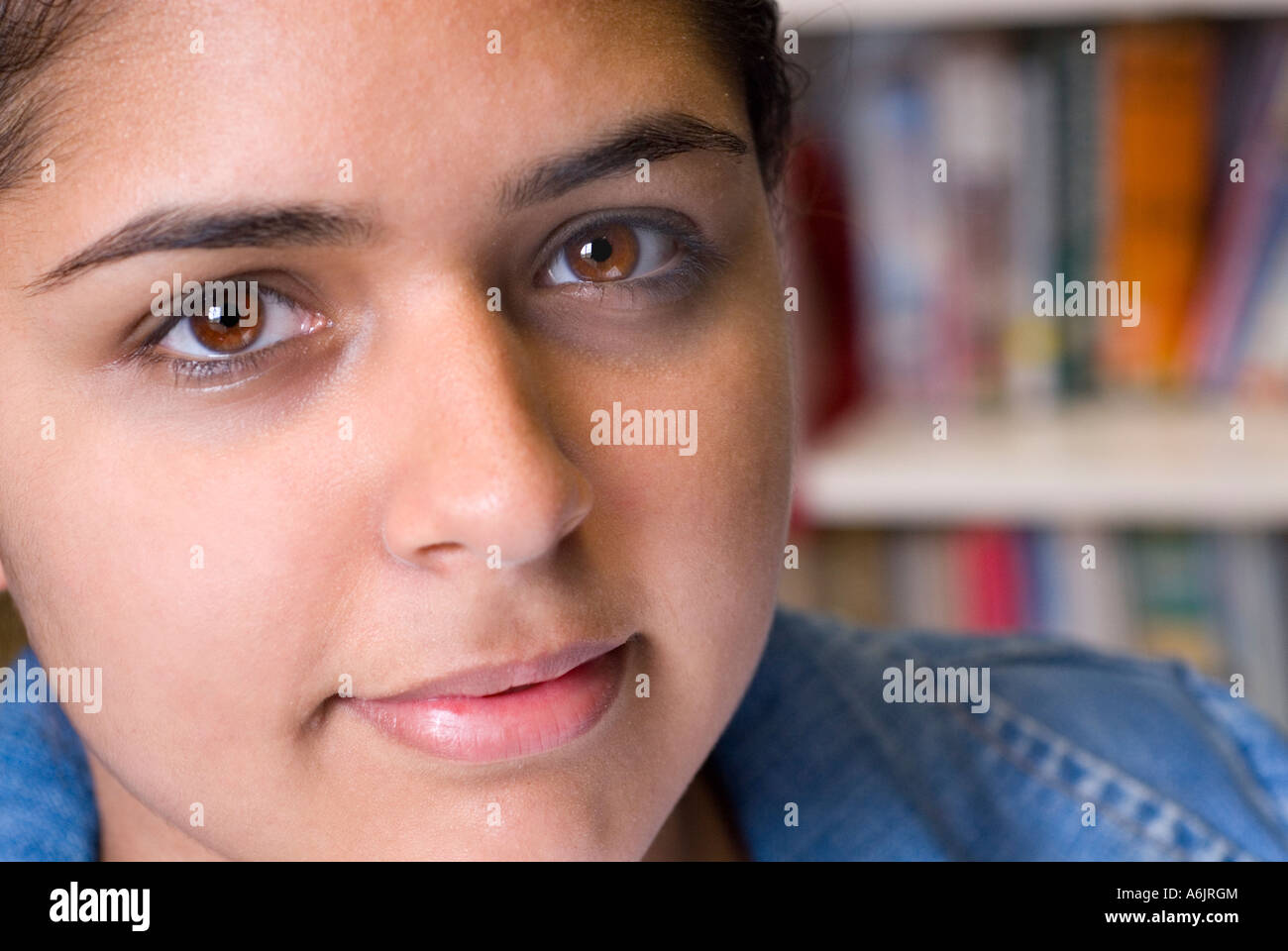 Close portrait of confident attractive Asian teenage girl student in school libary Stock Photo