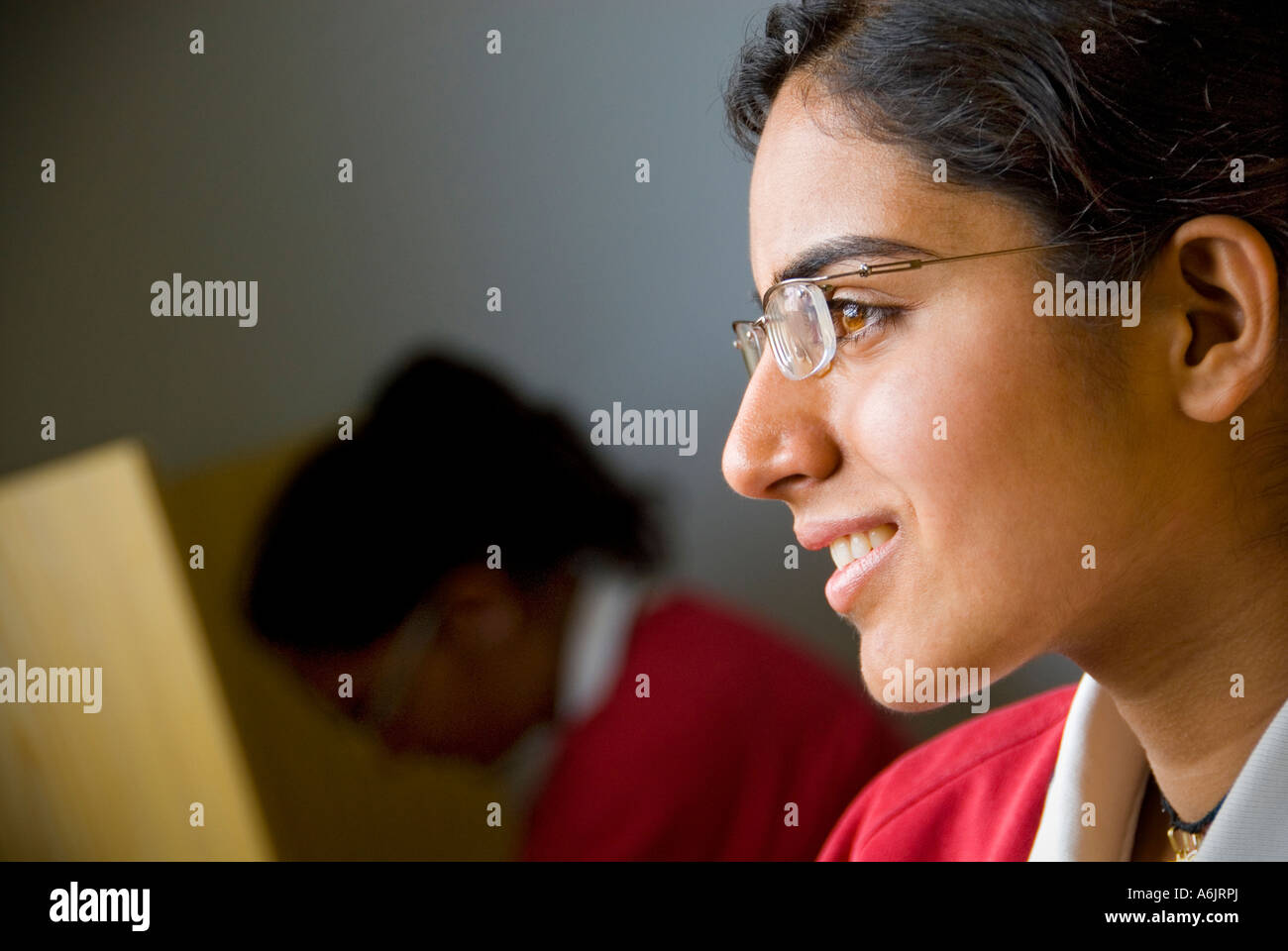 Asian Girl School Teenager 14-16 years senior high school girl pupil student wearing glasses smiling looking out of window school study library Stock Photo