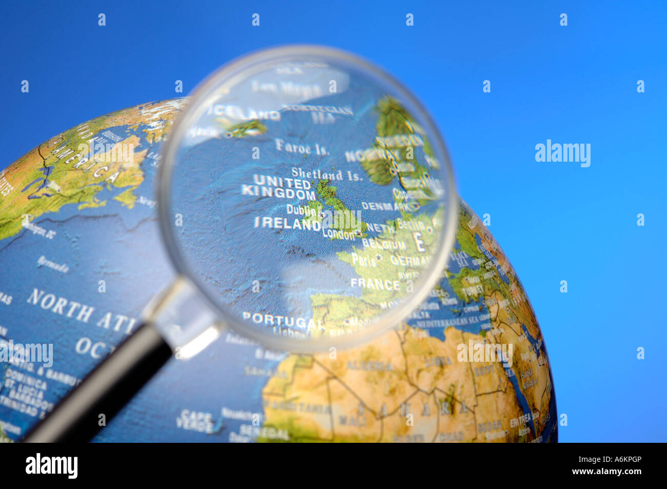 Magnifying glass and globe focussed on United Kingdom and Ireland Stock Photo