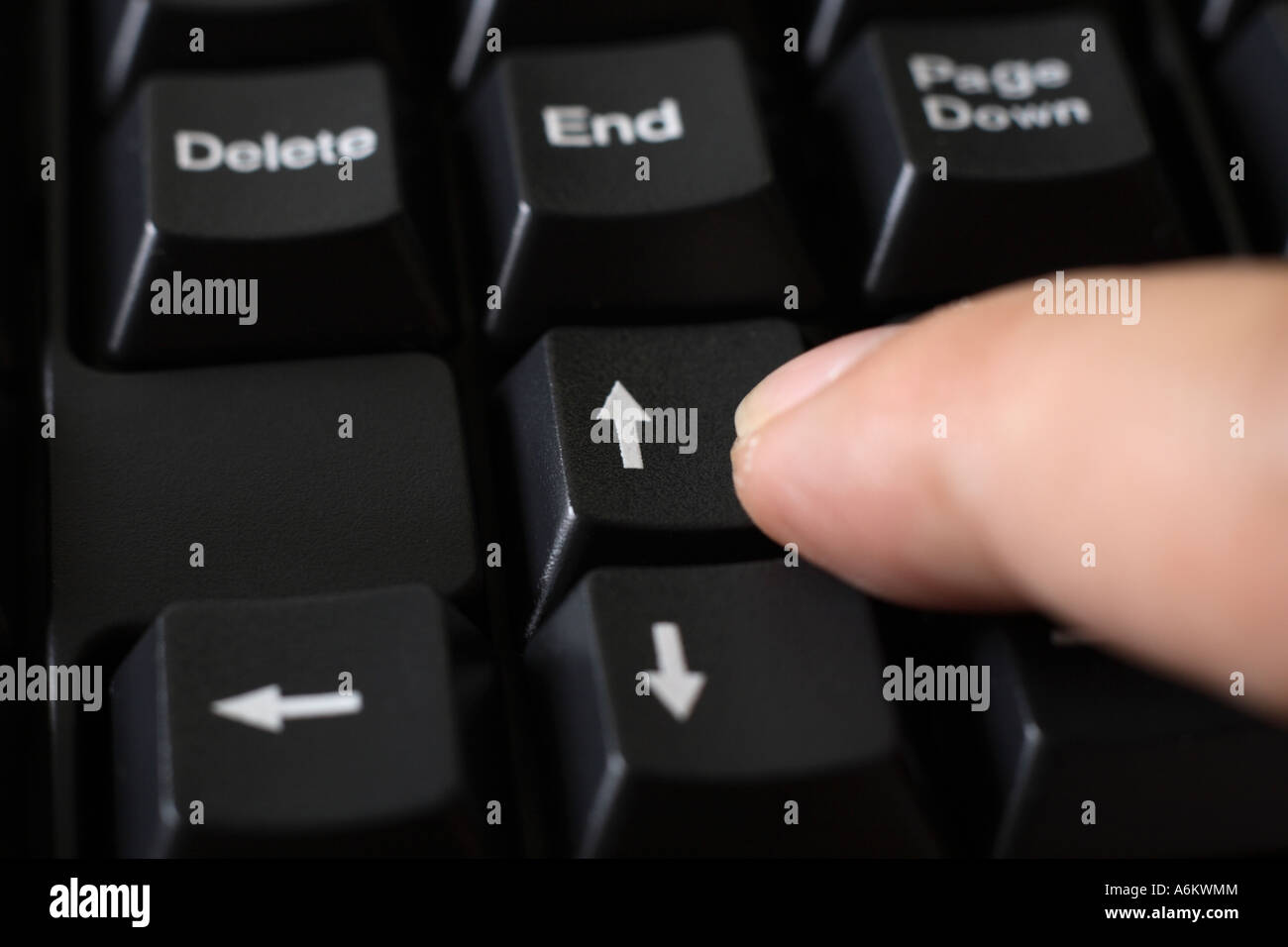 finger pressing up arrow button on black keyboard Stock Photo - Alamy