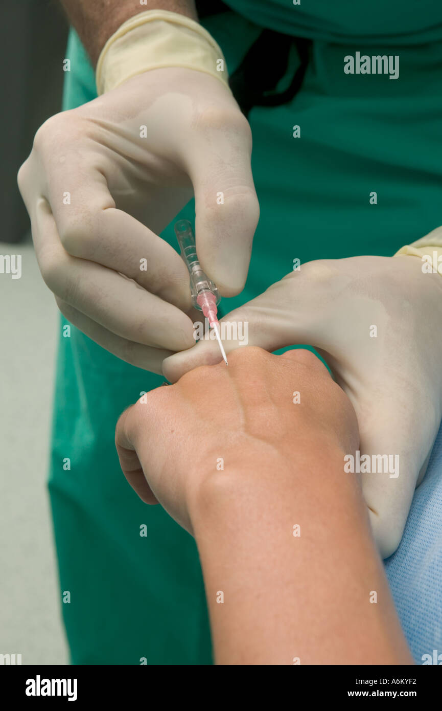 Anesthesiologist does blood work on patient during surgery Stock Photo