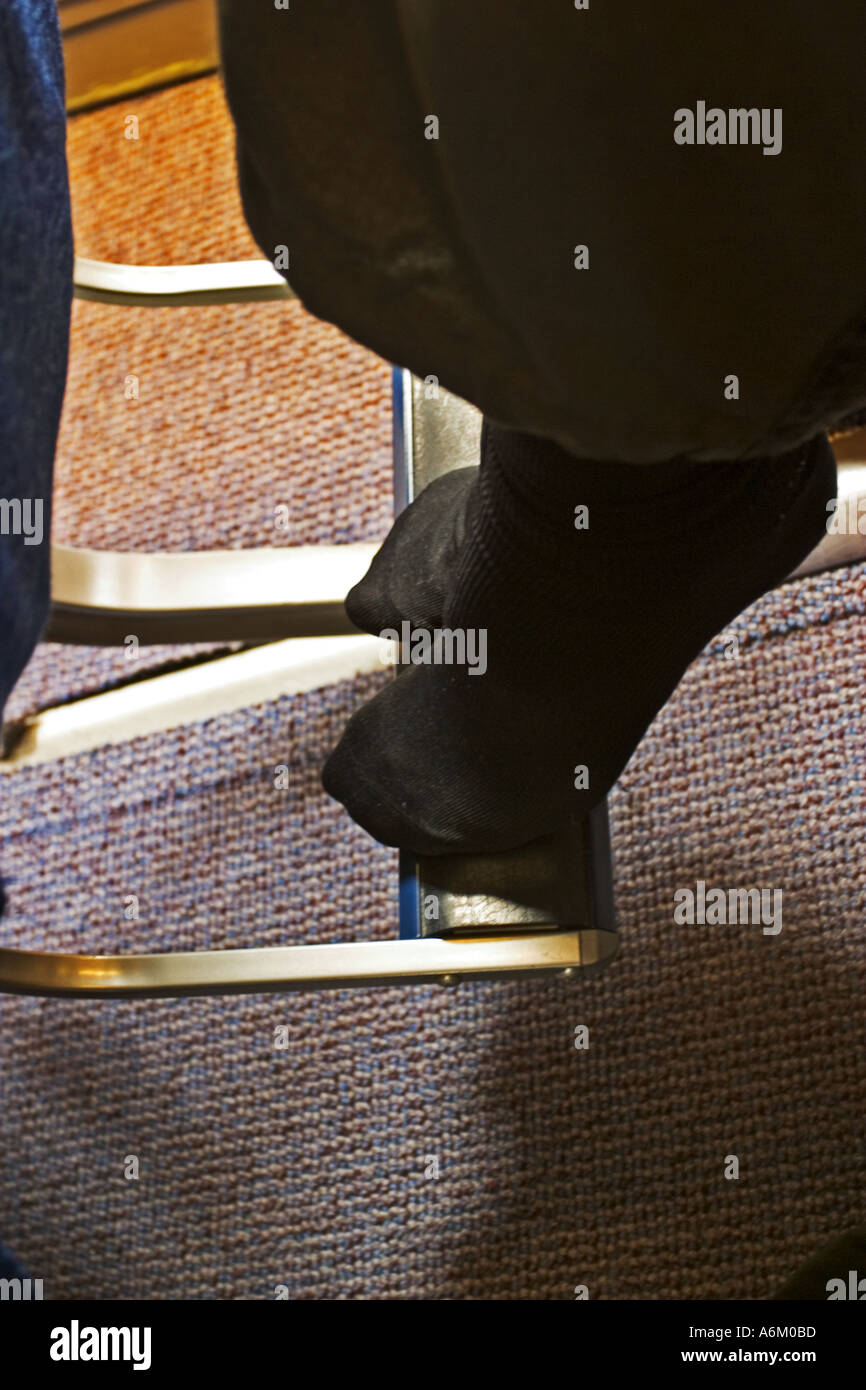 Wearing flight socks during long haul flight and resting feet on foot