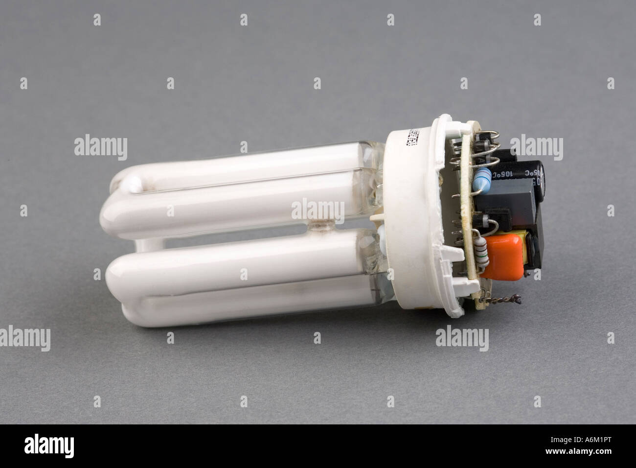 dismantled compact fluorescent lamp showing internal circuit board controller Stock Photo