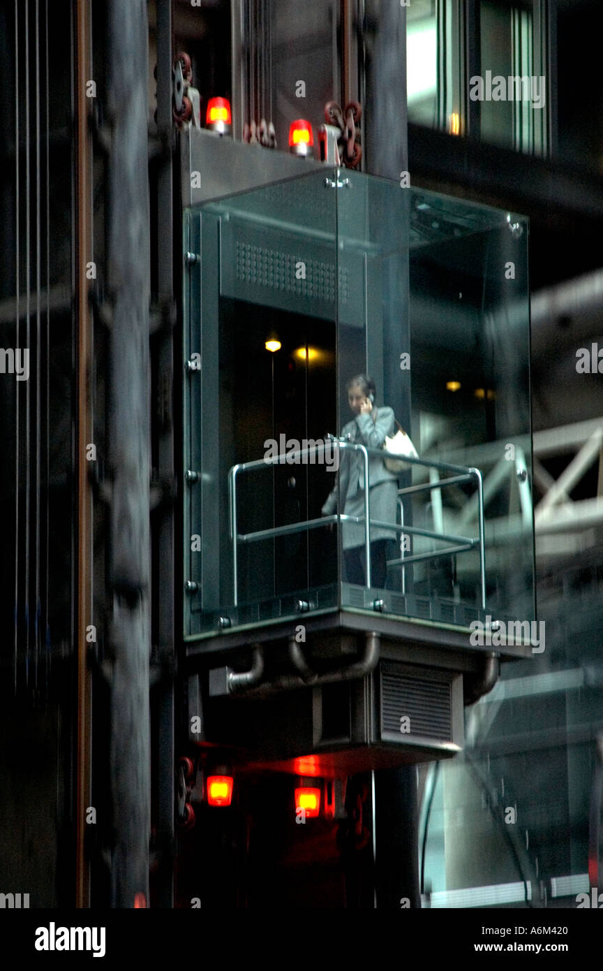 Office worker in glass elevator at Lloyds of London Stock Photo
