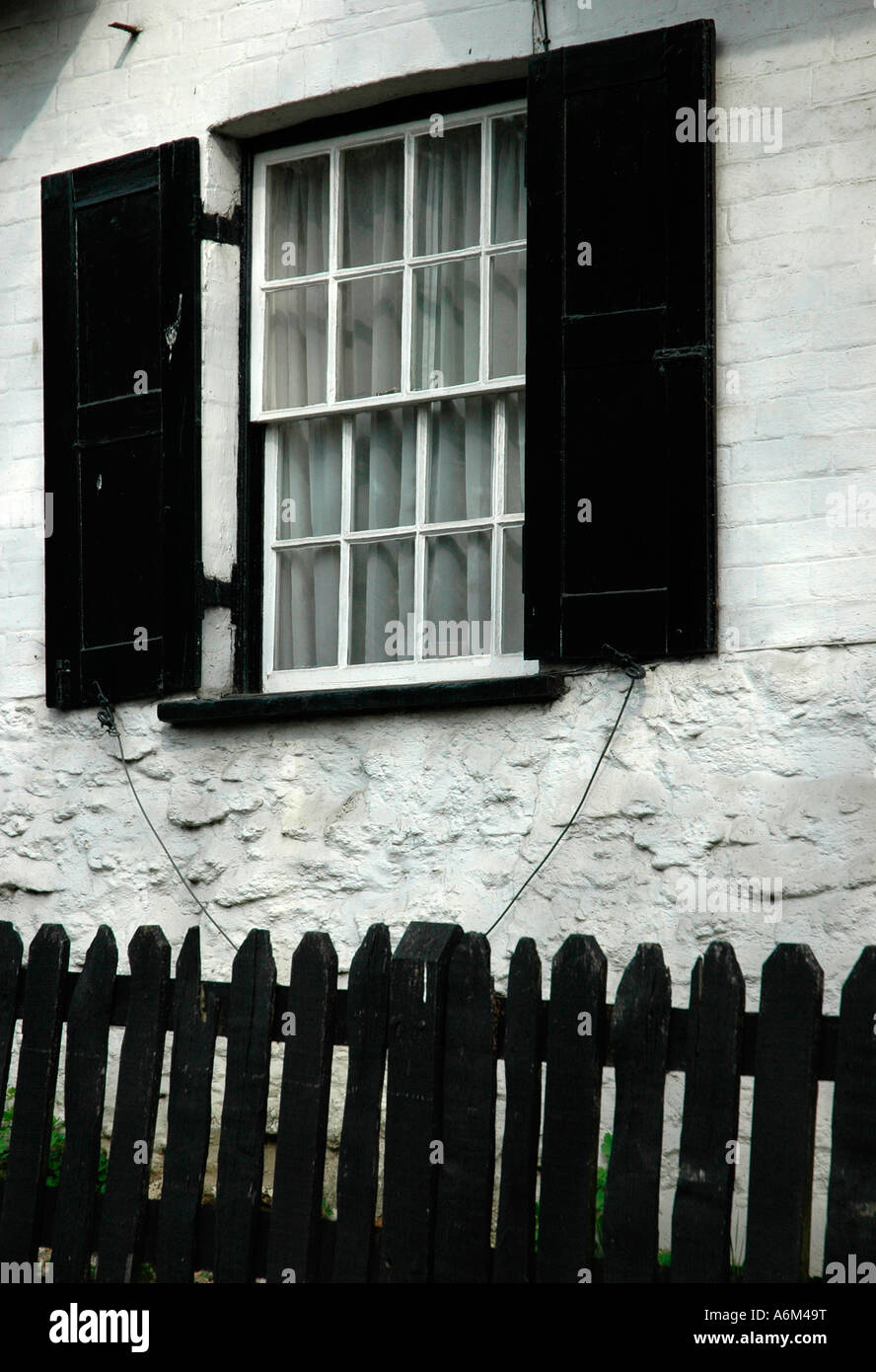Window with black wooden shutters on cottage in Oxfordshire countryside England Stock Photo