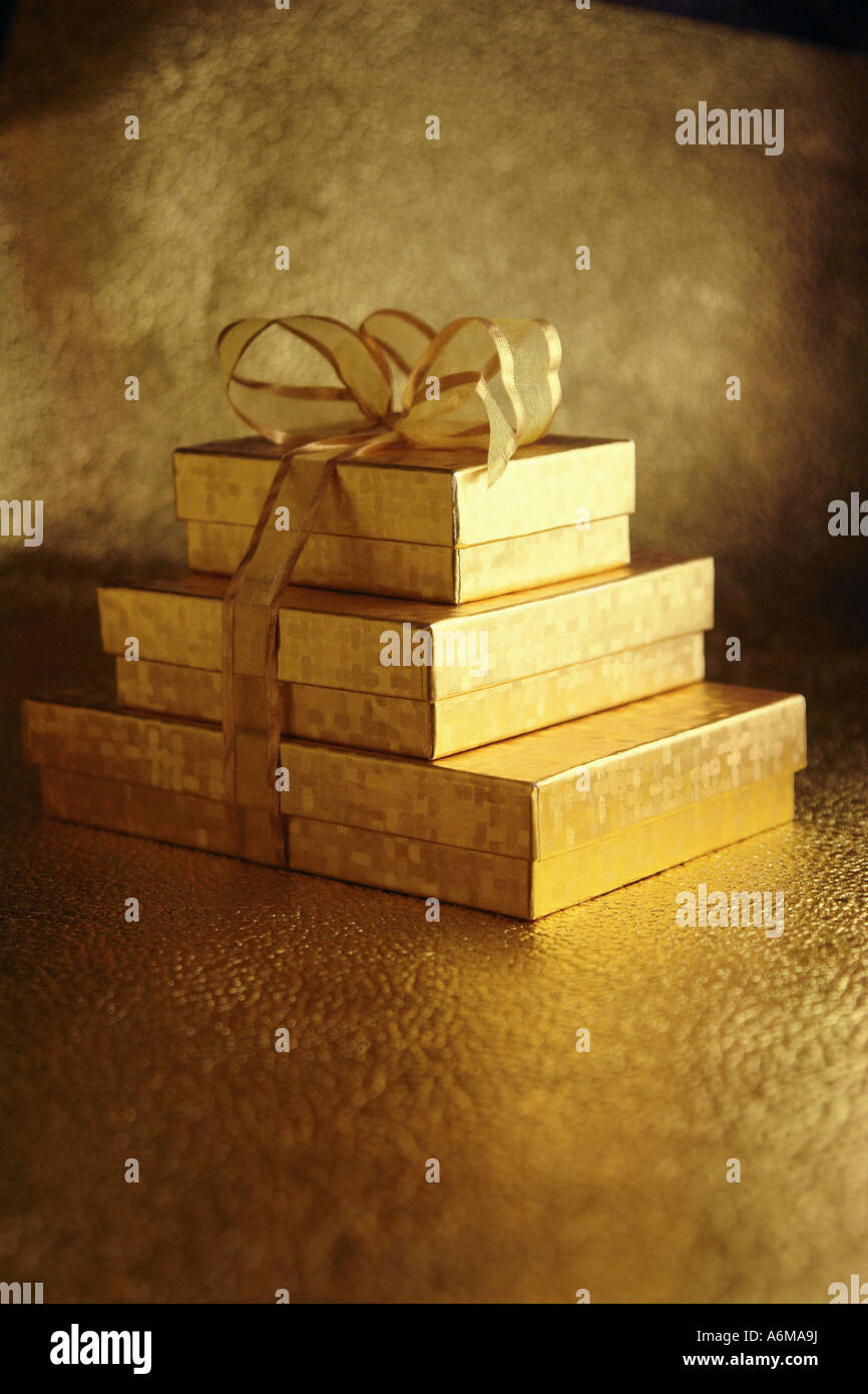 https://c8.alamy.com/comp/A6MA9J/stack-of-three-3-gold-gift-boxes-tied-together-with-gold-ribbon-copy-A6MA9J.jpg