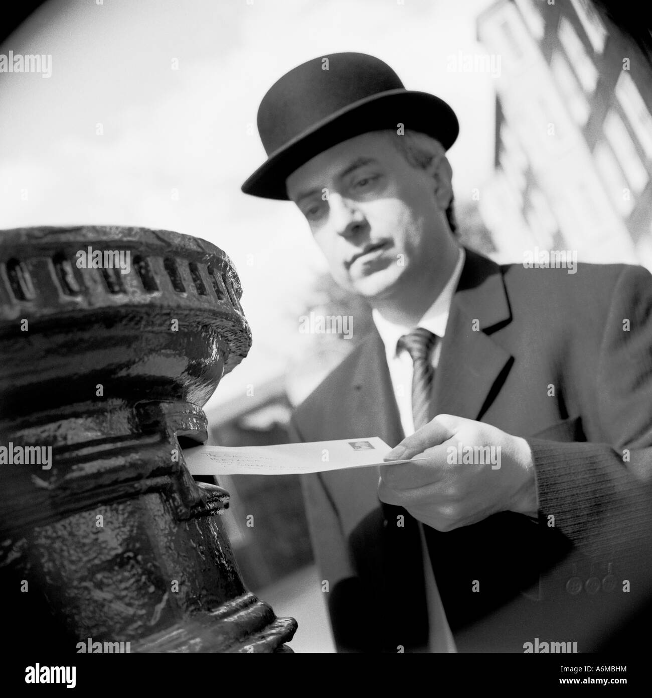 Englishman in bowler hat posting a letter Stock Photo