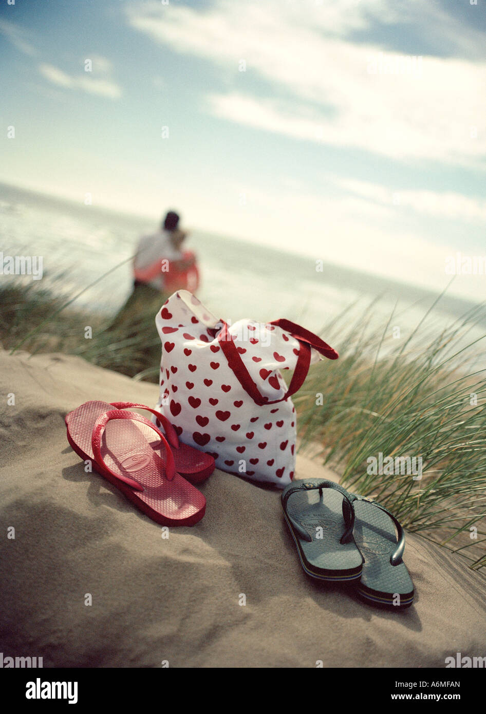 Lovers in the dunes looking at the sea Stock Photo