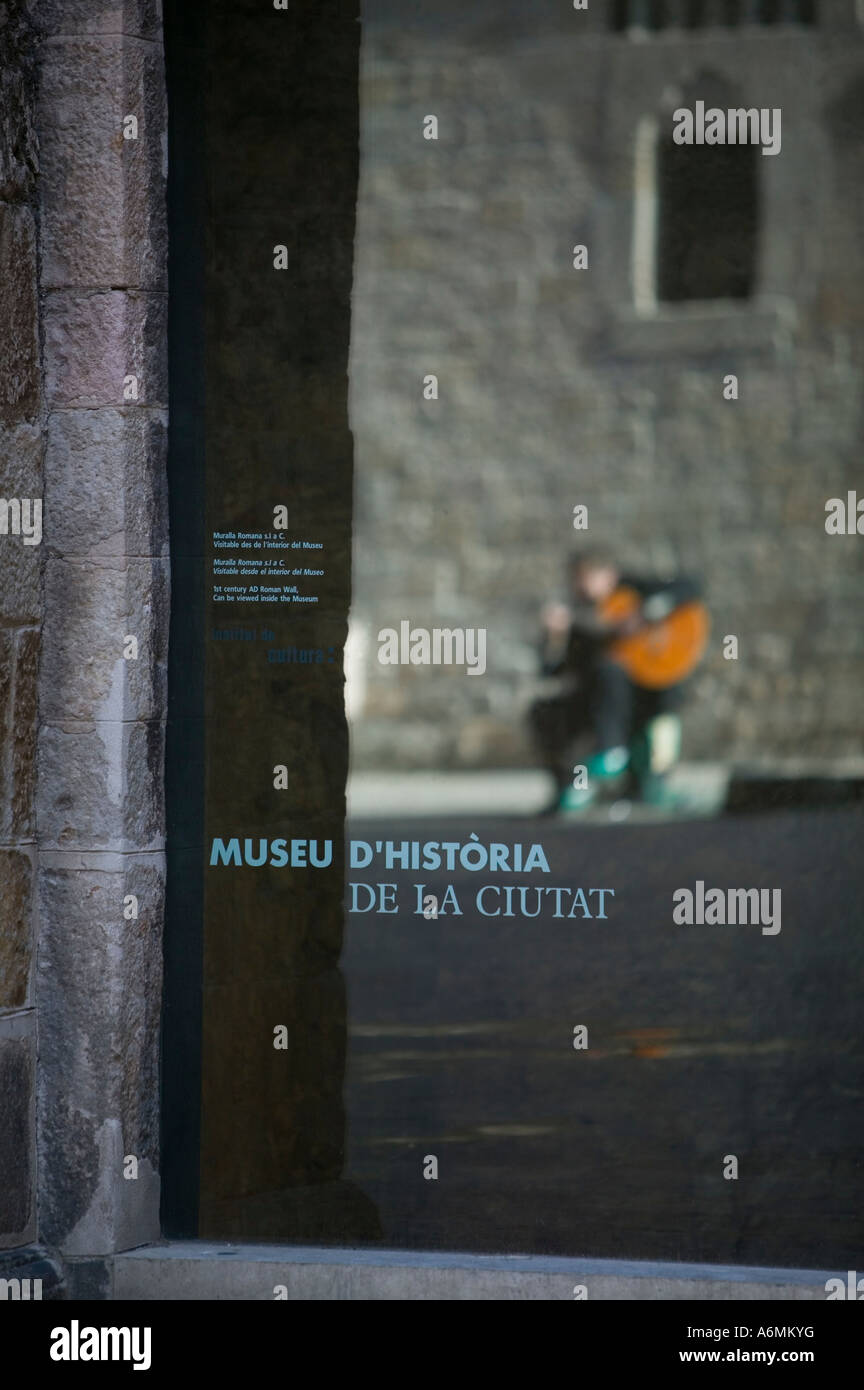 Spanish guitarist reflected in glass door of Museu D Historia de la Ciutat El Barri Gotic Gothic Quarter Barcelona Spain Stock Photo