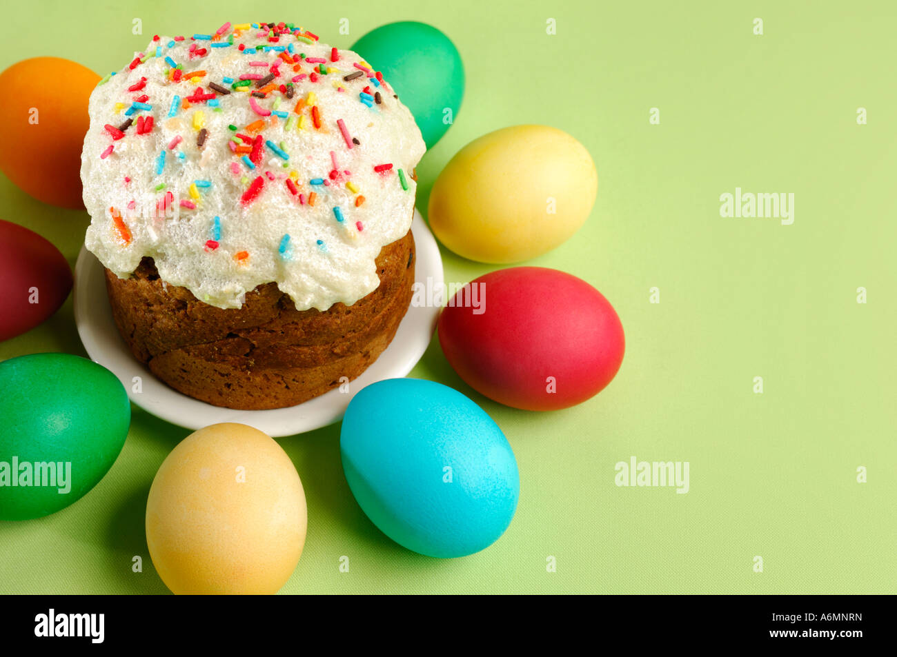 Easter cake and colorful Easter eggs on green Stock Photo
