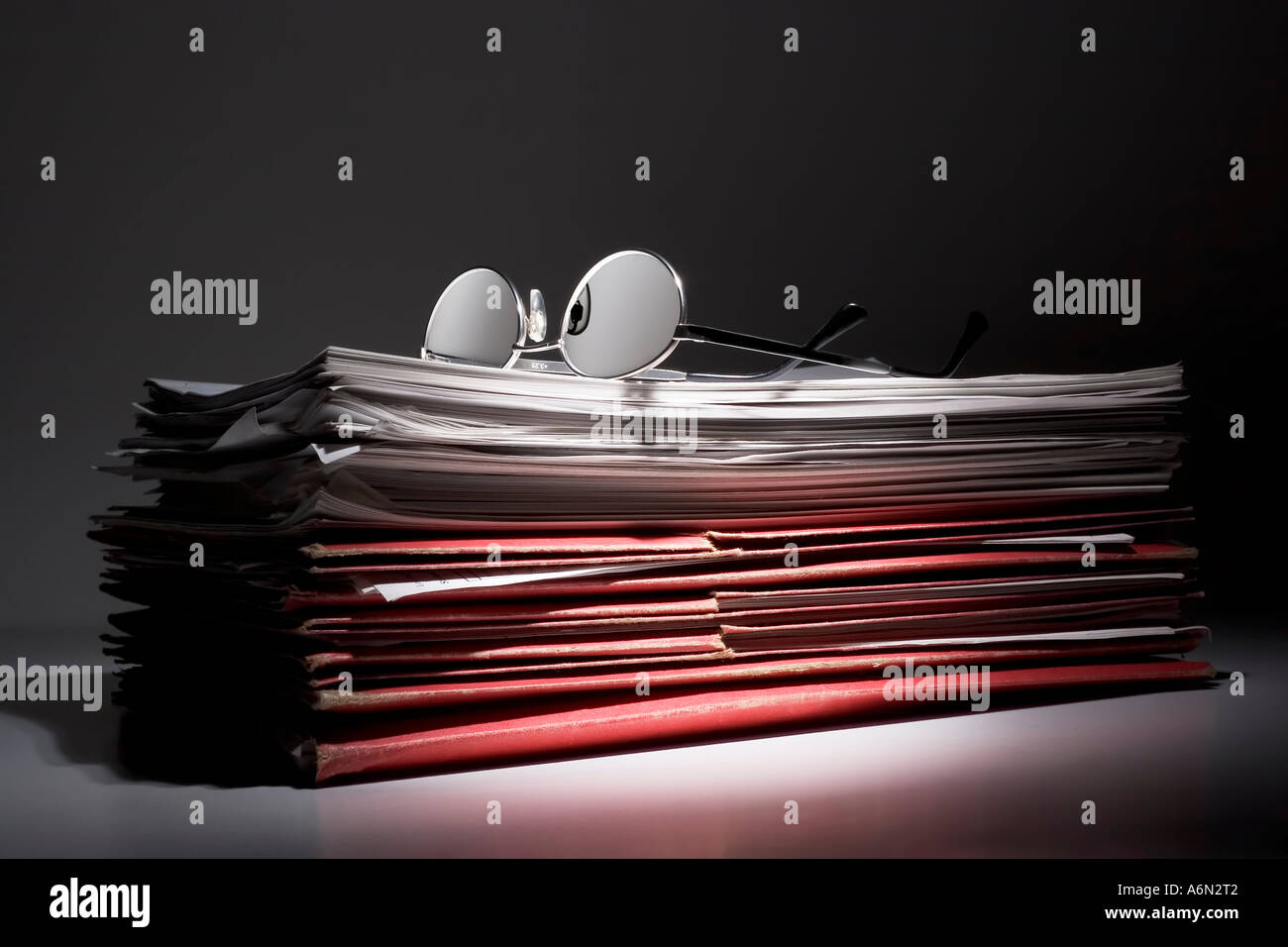 Eyeglasses on a stack of papers and folders Stock Photo