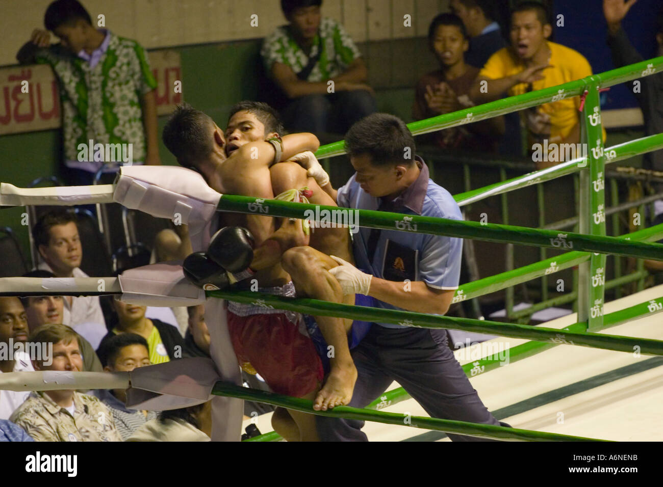 Fighters grappling in the corner during a Muay Thai fight (Rajadamnern