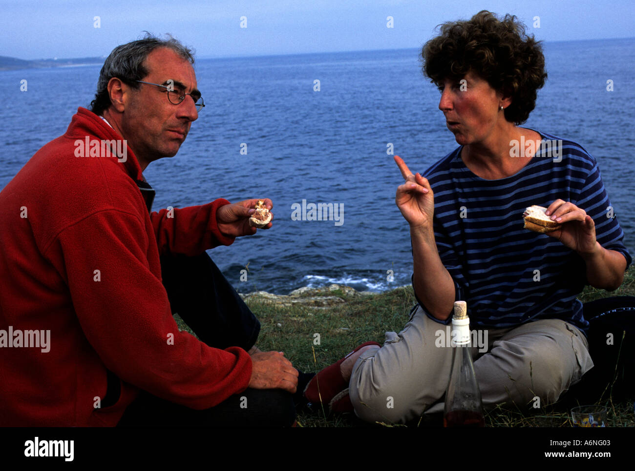 Husband and wife share a Picnic beside the Atlantic Ocean in Brittany France Stock Photo Alamy