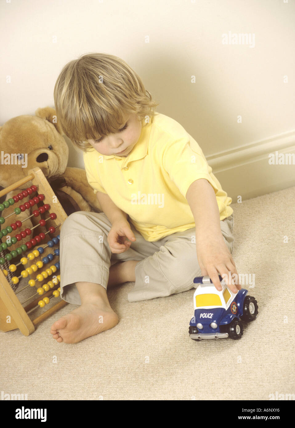 Young boy playing with plastic toy emergency vehicles Stock Photo