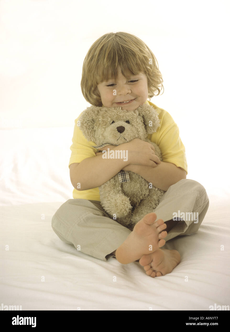 Happy young boy cuddling a teddy bear Stock Photo - Alamy