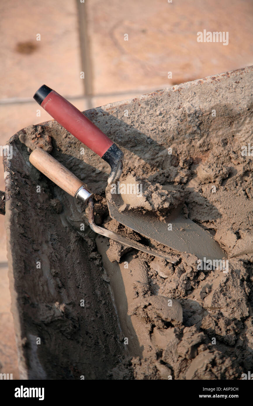 Builders wheelbarrow with fresh mix of cement or mortar and assorted