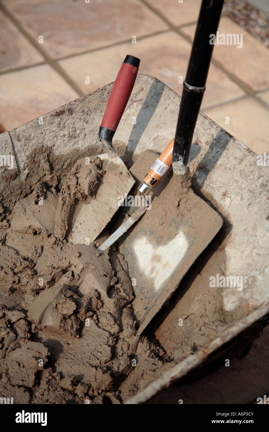 Builders wheelbarrow with fresh mix of cement or mortar and assorted